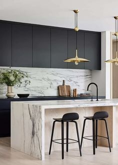 a kitchen with marble counter tops and stools