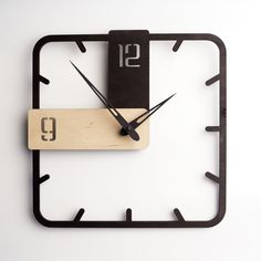 a square clock with black hands and numbers on the face is made out of wood