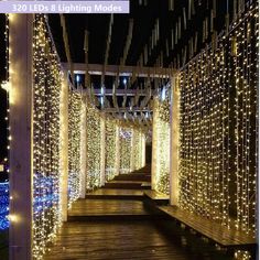 the walkway is lined with lights and poles that are covered in white string lights on both sides