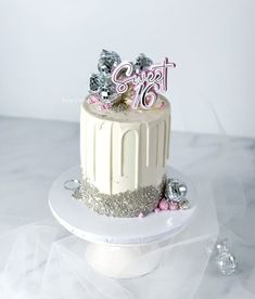 a white cake with silver and pink decorations