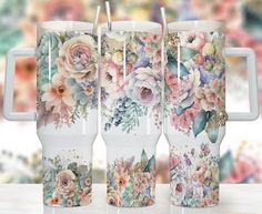 three coffee mugs with floral designs on them sitting on a table next to each other