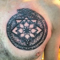 a man with a tattoo on his chest has a snake and flower in the center