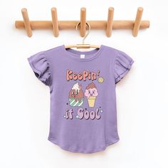 Looking for a cute tee for your daughter? We have the perfect flutter sleeve graphic tee. Playful Purple Tops With Cartoon Print, Purple Cartoon Print Tops For Spring, Playful Purple Short Sleeve T-shirt, Cute Purple Top With Graphic Print, Cute Purple Short Sleeve T-shirt, Cute Lavender Cotton Top, Cute Purple Top With Letter Print, Playful Purple Short Sleeve Tops, Cute Purple Spring T-shirt