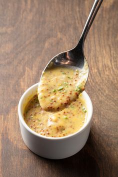 a spoon full of soup on top of a wooden table