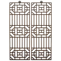 a pair of iron screens with geometric designs on them, set against a white background