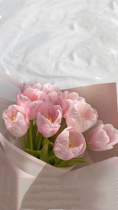 a bouquet of pink tulips in a paper bag