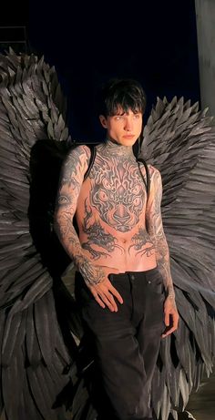 a man with tattoos and wings on his body