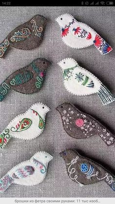 several embroidered birds sitting on top of each other