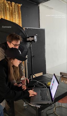 two people sitting at a table with a laptop