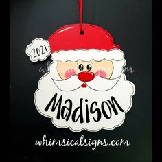 a christmas ornament with a santa clause on it's face and name