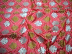 pink and gold brocaded fabric with white flowers on the top, in very close up