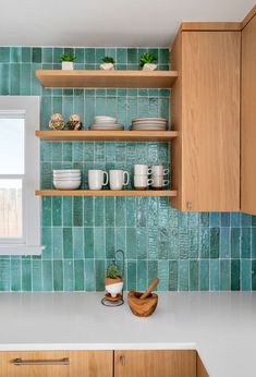 the kitchen counter is clean and ready to be used for cooking or baking, as well as dishes on wooden shelves