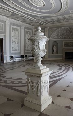 a large white statue in the middle of a room with marble flooring and walls