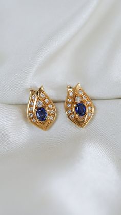 * Earring Material: Sapphire, Diamond, 18K Yellow Gold * Earring Width: 0.6x0.3 Inch * Stone Weight & sizes: Sapphire - 0.30ct, Diamond - 1.00ct * Overall weight: 4.2g * Earring material: 18k yellow gold, Push Back Post Gold Sapphire Earrings For Anniversary, Sapphire Earrings For Anniversary, Gold Sapphire Diamond Earrings As Gift, Gold Diamond Cluster Earrings With Gemstones, Yellow Gold Oval Earrings, Gold Sapphire Diamond Earrings For Anniversary, Yellow Gold Sapphire Diamond Earrings For Anniversary, Anniversary Sapphire In Yellow Gold Diamond Earrings, Anniversary Yellow Gold Sapphire Diamond Earrings