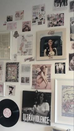 a wall covered in pictures and posters with vinyl records on the wall next to it