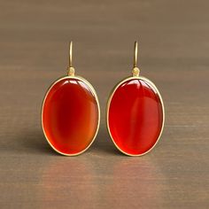 A smooth surface radiates the glowing light captured by fire-orange carnelian in this inviting pair. 18k yellow gold Carnelian, 25.65ctw, 17mm x 24mm (11/16" x 15/16")Earrings hang 1 7/16" from the ear Each earring weighs 6.4g Fire Orange, Carnelian Earrings, Orange Carnelian, Newport Rhode Island, Newport Ri, Unique Necklaces, Newport, Gold Jewelry, New Arrivals