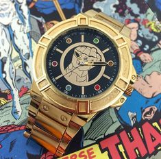 a gold watch sitting on top of a comic book with an image of a cartoon character