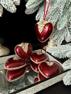 red heart shaped ornaments hanging from a christmas tree