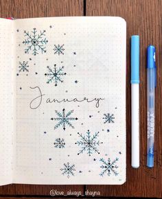 an open notebook with the word january written on it next to a pen and marker