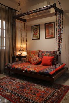 a living room with a bed, rugs and pictures on the wall above it