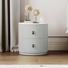 a white cabinet with two flowers on top