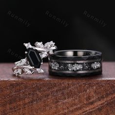 two wedding rings with diamonds and black onyxite are sitting next to each other