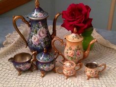 there is a tea set and a rose on the table