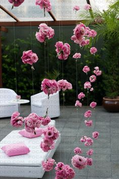 pink flowers are floating in the air over white couches