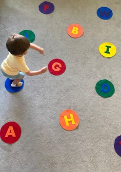 a toddler playing with letters on the floor