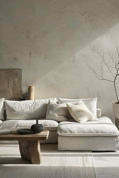 a living room with a white couch and coffee table in front of a wall mounted planter