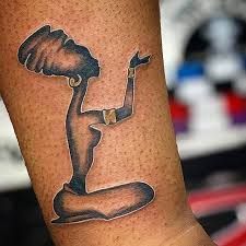 a woman's arm with a tattoo on it that has an image of a statue