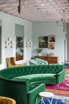 a living room filled with green couches and colorful rugs