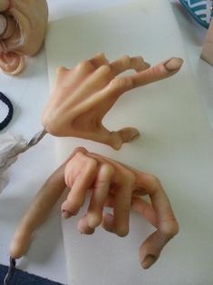 the hands are being made out of clay and paper machs on top of a table