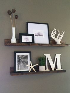 two wooden shelves with pictures, frames and plants on them in the corner of a room