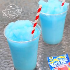 two glasses filled with blue liquid next to a candy bar