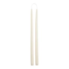 two white candles sitting next to each other