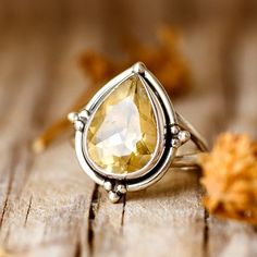 Crafted from gleaming sterling silver, this ring showcases a mesmerizing teardrop-shaped citrine gem, adding a touch of warmth and brightness to any outfit. The delicate band and simple design make it perfect for stacking or wearing solo. This ring features a natural, genuine, unique gemstone handpicked from our current collection. The actual gemstone you receive will be one-of-a-kind and may be different from the photos, making your ring truly special. ❥ Metal: Solid sterling silver ❥ US Ring Size: Choose Size ❥ Width: 20mm ❥ Gemstone: Citrine ❥ Gemstone Color: Yellow ❥ Gemstone Size: 15mm Yellow Stone Ring, Yellow Stone Rings, Moonstone Ring Sterling Silver, Pear Ring, Citrine Jewelry, Teardrop Ring, Gem Ring, Citrine Ring, Yellow Stone