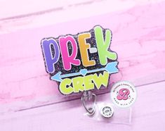 "Pre-K crew badge reel: If you are looking for a unique gift then look no further! This retractable badge reel is perfect for any occasion.  Acrylic is 2\" Cord length 34\" You may choose a swivel clip, belt clip, lanyard, or carabiner. All badge reels come with dual lock fastener. They are interchangeable! Please do not allow children to play with the badge reels. Made in a smoke free studio. Don't hesitate to send me a message if you have questions. I will usually respond back within an hour f Personalized Multicolor Badge Reel For Teacher Appreciation, Personalized Fun Badge Reel For Gift, Personalized Fun Badge Reel Gift, Playful Multicolor Badge Reel For Gifts, Playful Multicolor Badge Reel As Gift, Personalized Fun Craft Supplies For Teacher Appreciation, Novelty Adjustable Badge Holders For School, Personalized Fun Badge Reel For Hobbies, Personalized Fun Badge Reel For Hobby