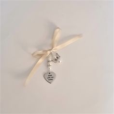 "This is a beautiful charming handmade silver bridal bouquet charm with  a personalised \"Walk with me today\" charm and a  hand crafted angel charm . In this example, the \"Walk with me today\" charm is suspended beneath a string of 3 White Pearl Beads with 2 Diamante Rondelle Spacer beads between the pearls;   the angel charm is handcrafted from 2 White pearls and tibetan silver angel wings.  The bouquet charm is supplied with a 30 cms length of ivory ribbon, ready for you to attach to your bouquet, and  comes in a pretty organza gift bag. It will make a superb addition to your very special day.  You can change the colour of the angel and the colour of the pearl strings  for the \"Walk with me today\" charm at check out.  This listing is for a single  \"Walk with me today\" charm, and 1 Charming Wedding Jewelry With Flower Charm, Elegant Charms For Anniversary And Mother's Day, Valentine's Day Wedding Jewelry With Vintage Charm, Elegant Wedding Charms With Vintage Style, Elegant Wedding Charms With Vintage Design, Heart-shaped Wedding Jewelry With Flower Charm, Heart-shaped Jewelry With Flower Charm For Wedding, Vintage Charm For Valentine's Day Gift, Elegant Silver Wedding Charms