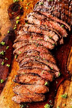 steak sliced up on a cutting board with parsley sprinkled around the edges