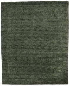 a green rug with an uneven design on the top and bottom corner, in front of a white background