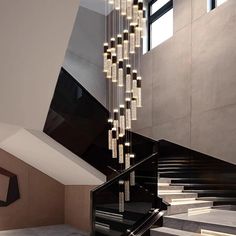 a staircase with chandelier hanging from it's side in a modern building