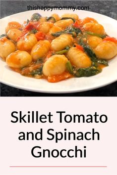 skillet tomato and spinach gnocchi on a white plate with the words, skillet tomato and spinach gnocchi