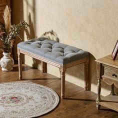 a bench sitting on top of a wooden floor next to a rug