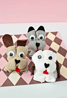 three stuffed animals sitting on top of a checkered table