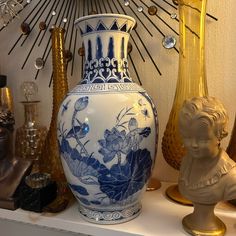 a vase sitting on top of a shelf next to other decorative items and glassware