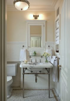 a bathroom with a sink, mirror and toilet in the corner next to a doorway