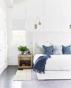 an instagram page with a white bed and blue throw pillows