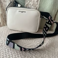 Karl Lagerfeld Maybelle Bag With Colorful Strap. Perfect For The Summer. Double Top Zipper Closure Exterior: 1 Back Slip Pocket Interior: 1 Slip Pocket, 3 Card Slits Adjustable Crossbody Strap 14" - 23" Strap Drop 9" W X 6" H X 3" D Spot Clean Imported Style Number: Lh0er9bj White Shoulder Bag With Logo Strap For Travel, White Bags With Logo Strap For Everyday Use, White Bag With Logo Strap For Everyday Use, White Crossbody Bag With Long Strap, Elegant White Bags With Logo Strap, White Crossbody Shoulder Bag With Long Strap, Chic White Bag Strap With Detachable Feature, Chic White Shoulder Bag With Logo Strap, Chic White Adjustable Bag Strap