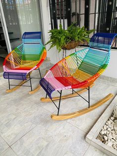 three colorful rocking chairs sitting on top of a patio